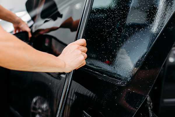 Window film being worked onto door glass during a window tinting North Las Vegas booking