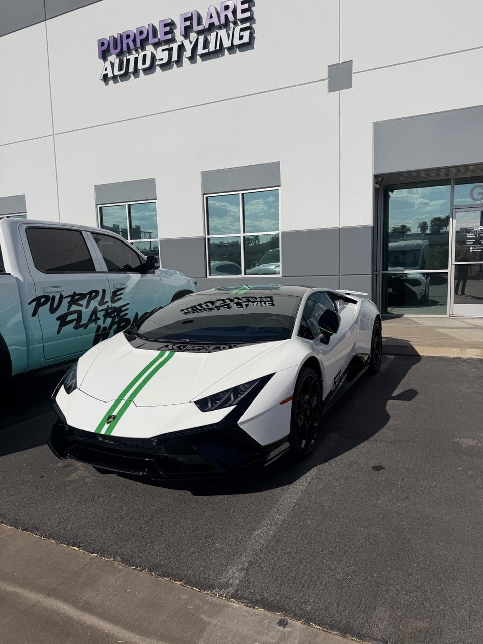 White Lamborghini Huracan with green racing stripes parked in front of Purple Flare Wraps shop Las Vegas