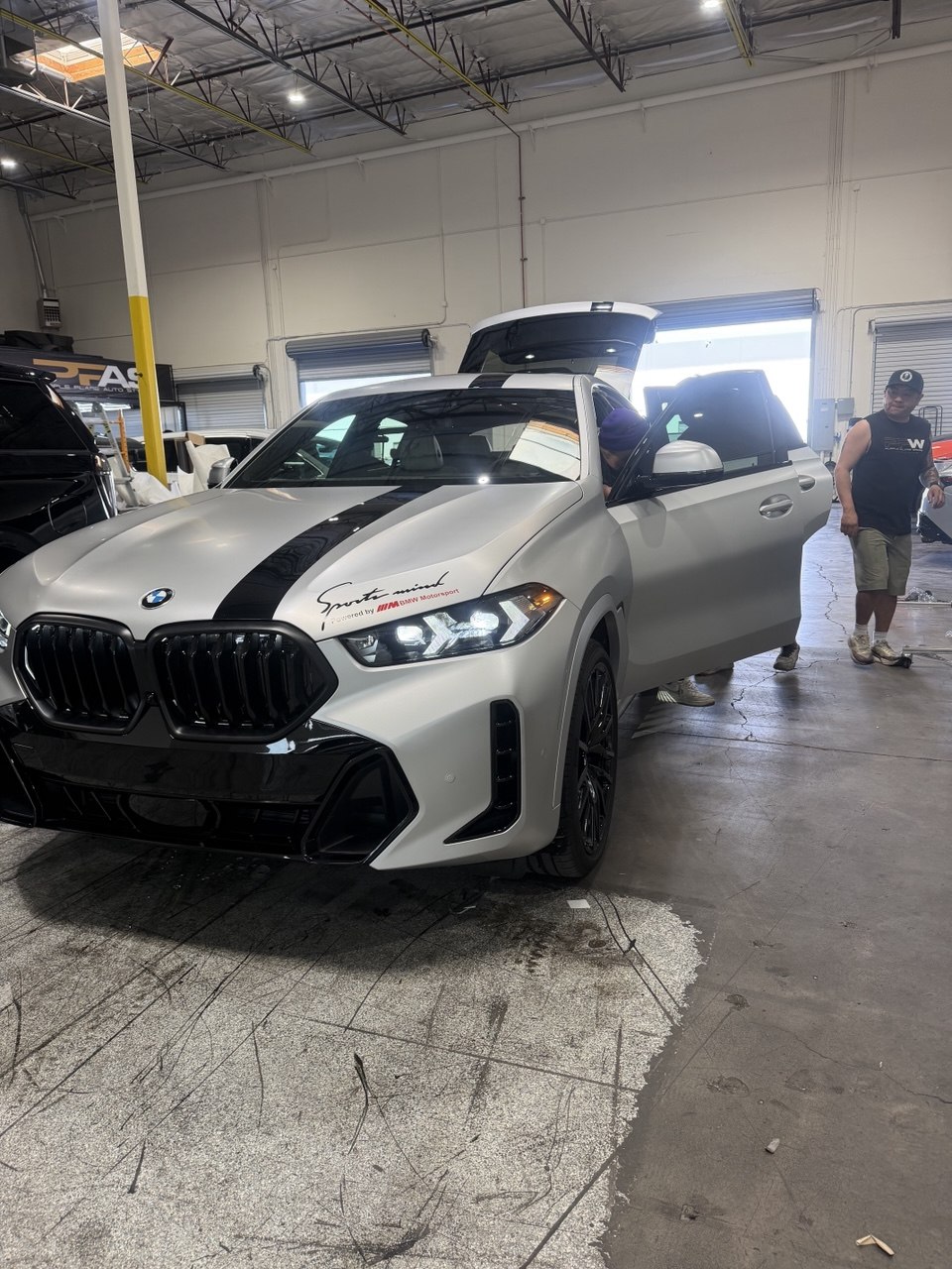 Matte white BMW X6 with black racing stripes vinyl wrap at Purple Flare Wraps serving North Las Vegas