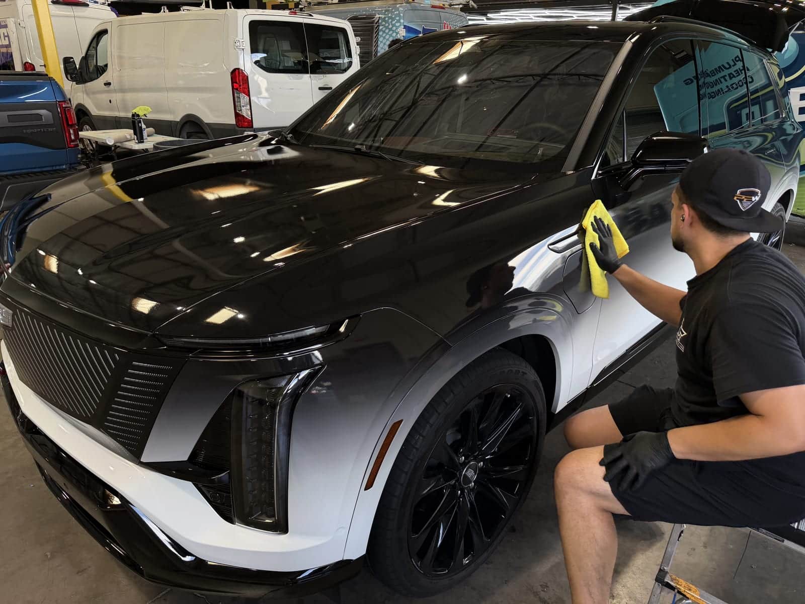 Technician levelling ceramic coating on a coated panel
