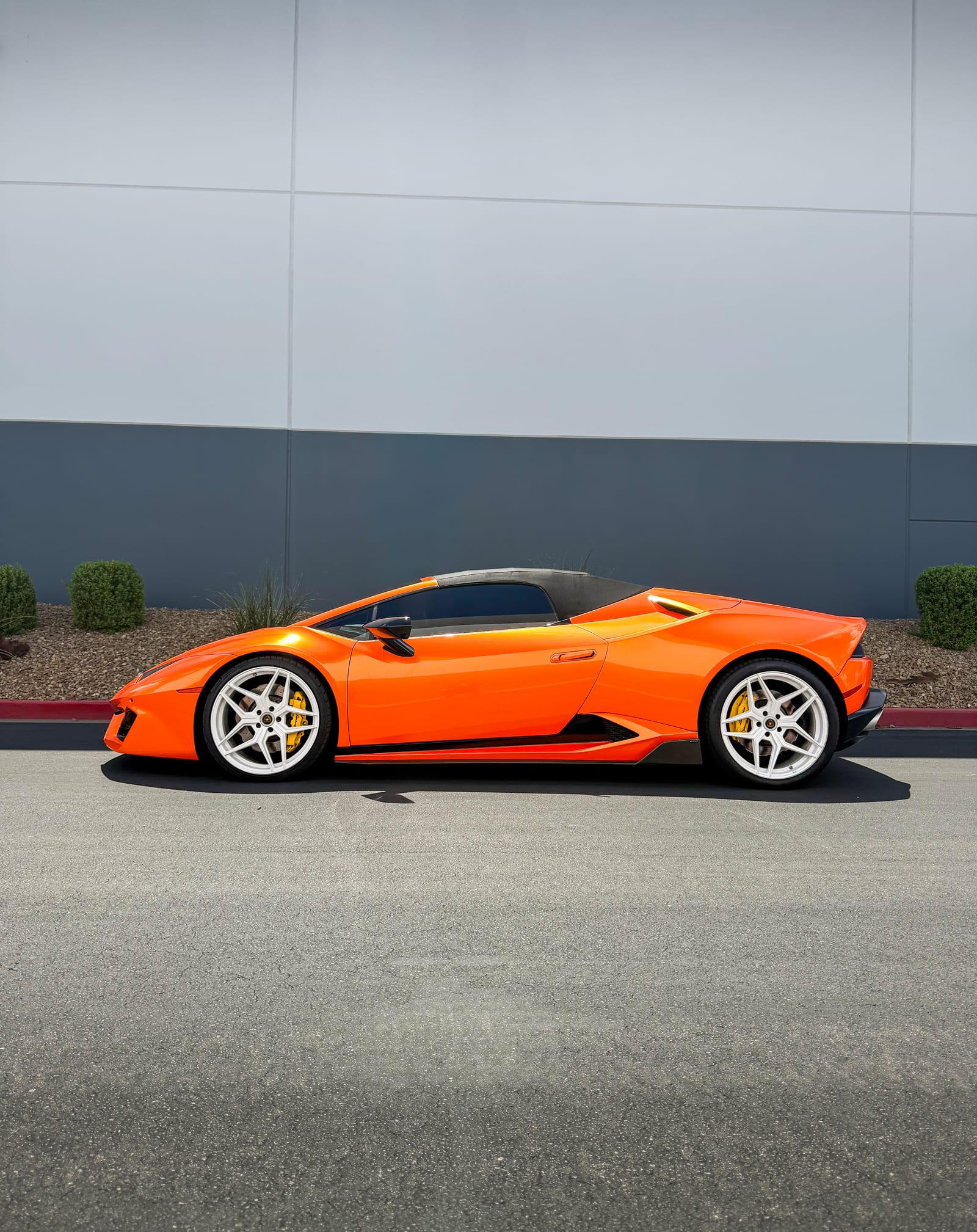 orange car wrap — side profile of the gloss orange Lamborghini Huracan Spyder on white wheels