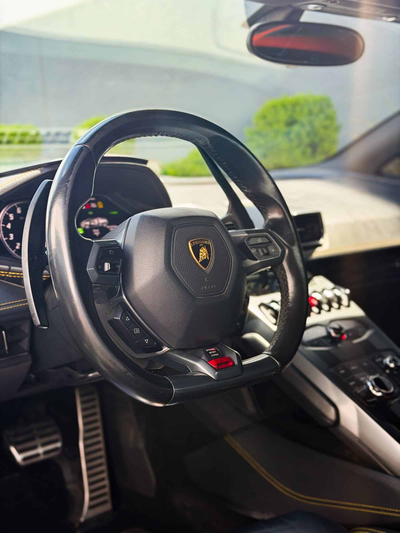 orange car wrap — Lamborghini Huracan interior and steering wheel with yellow stitching