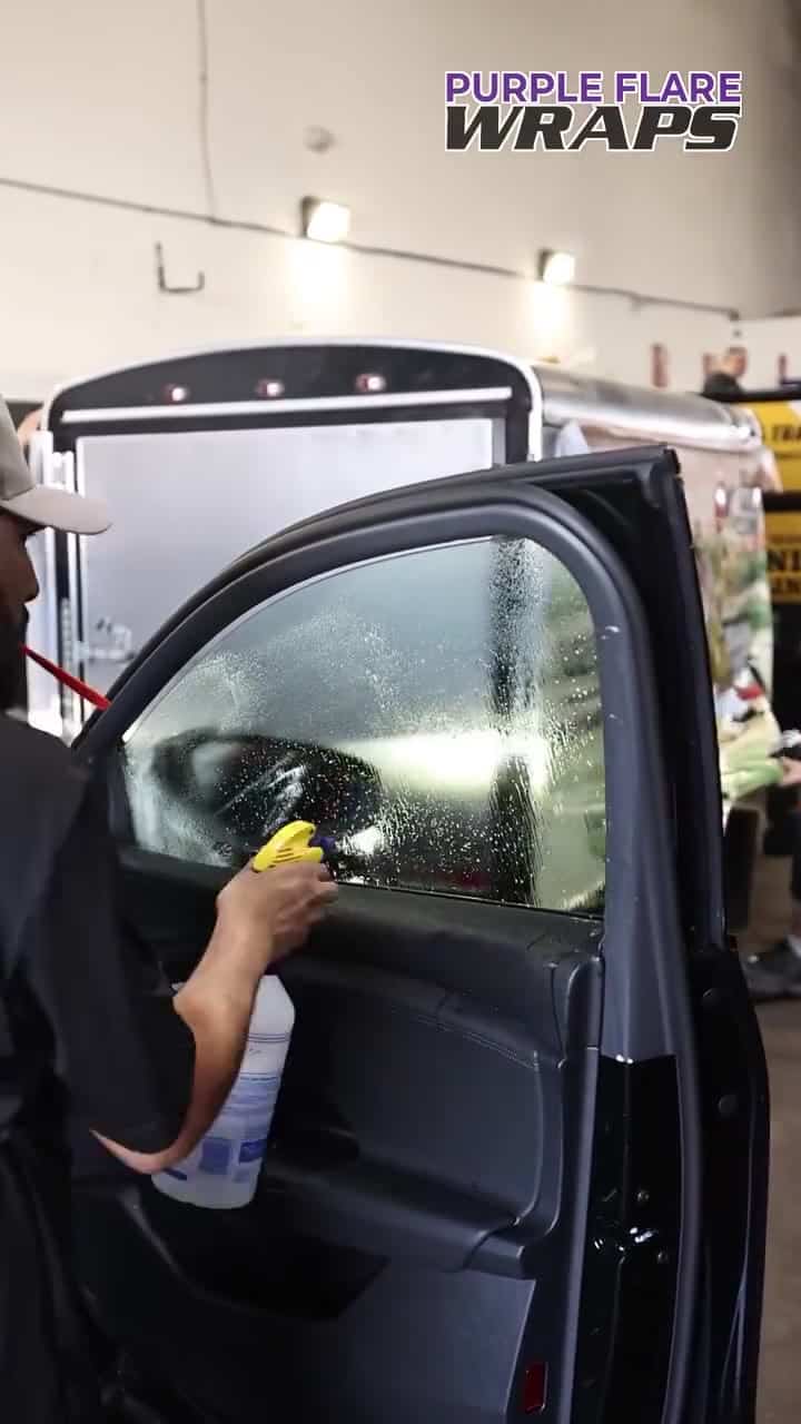 Window tinting Las Vegas install, film being squeegeed onto door glass